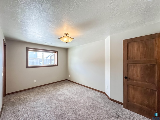 spare room with a textured ceiling and carpet