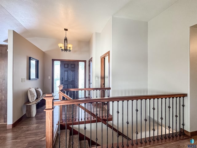 entrance foyer with dark hardwood / wood-style floors, a chandelier, and vaulted ceiling