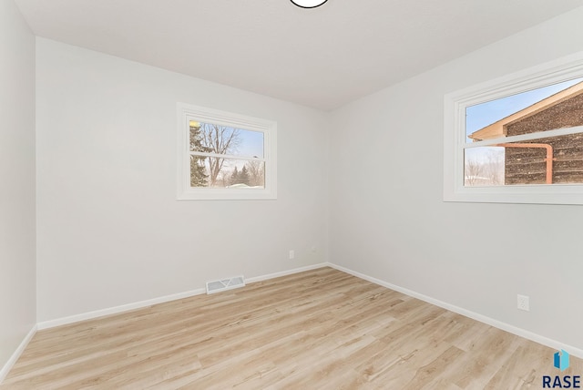 empty room featuring plenty of natural light and light hardwood / wood-style floors