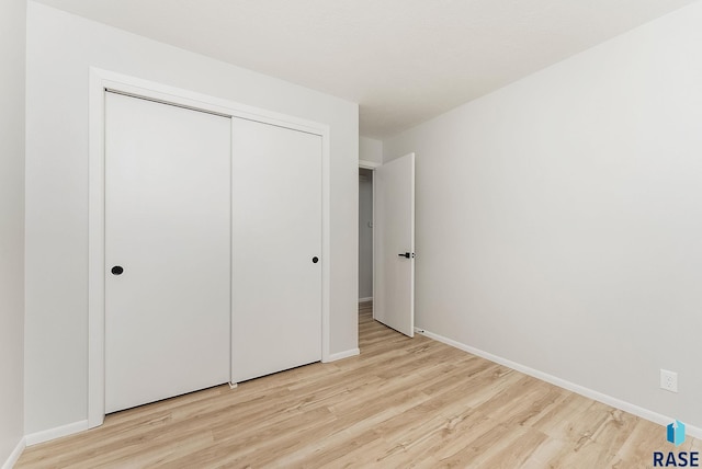 unfurnished bedroom featuring light hardwood / wood-style floors and a closet