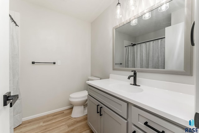 bathroom with wood-type flooring, vanity, and toilet