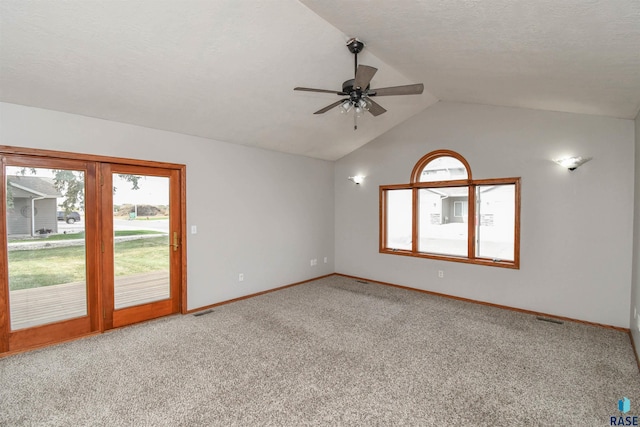 unfurnished room with ceiling fan, carpet flooring, vaulted ceiling, and a textured ceiling