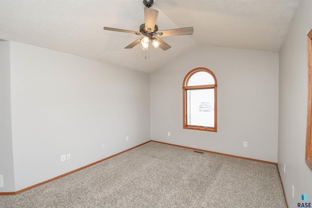 carpeted empty room with ceiling fan, lofted ceiling, and a textured ceiling