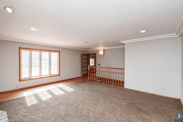 unfurnished room with crown molding and a textured ceiling