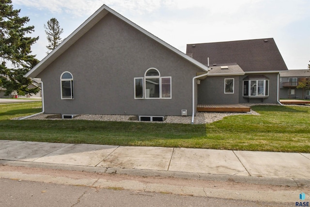 view of side of home featuring a wooden deck and a yard