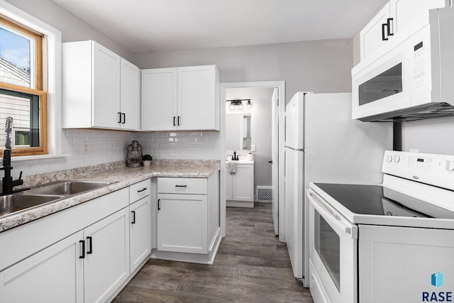 kitchen with white cabinetry, white appliances, sink, and tasteful backsplash