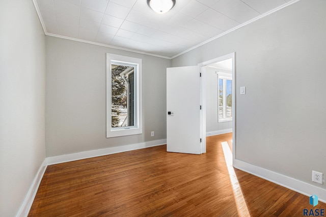 spare room featuring hardwood / wood-style floors and crown molding