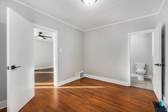 unfurnished bedroom with wood-type flooring, crown molding, and ensuite bath