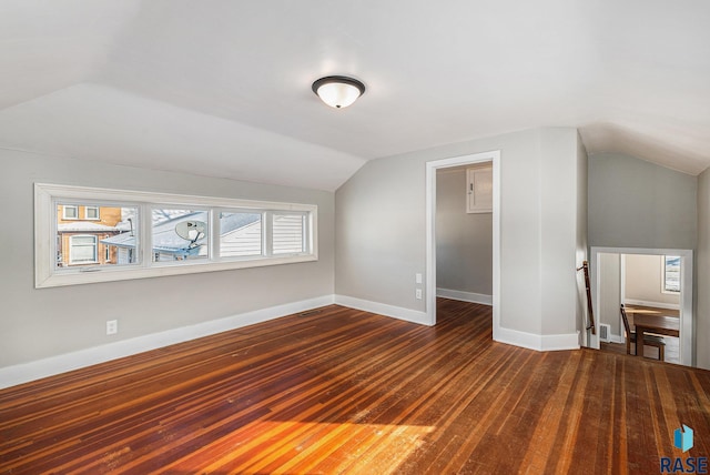 additional living space featuring dark wood-type flooring and lofted ceiling