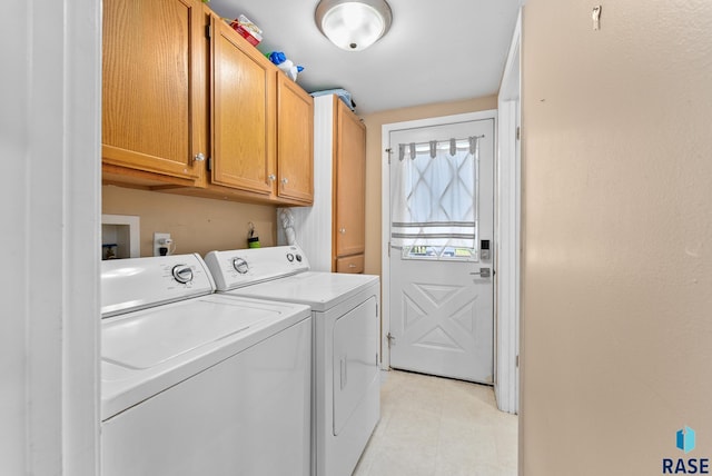 clothes washing area with independent washer and dryer and cabinets