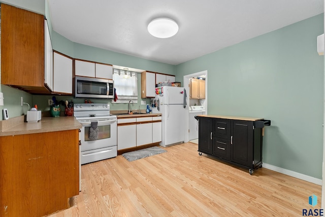 kitchen featuring white cabinetry, sink, white appliances, and light hardwood / wood-style floors