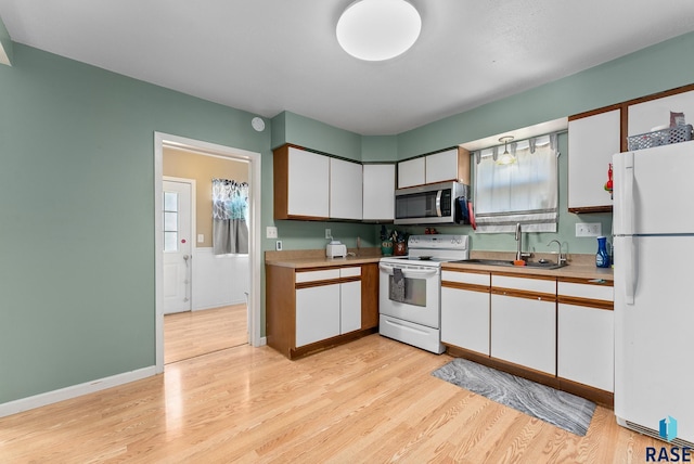 kitchen featuring white cabinetry, white appliances, sink, and light hardwood / wood-style flooring