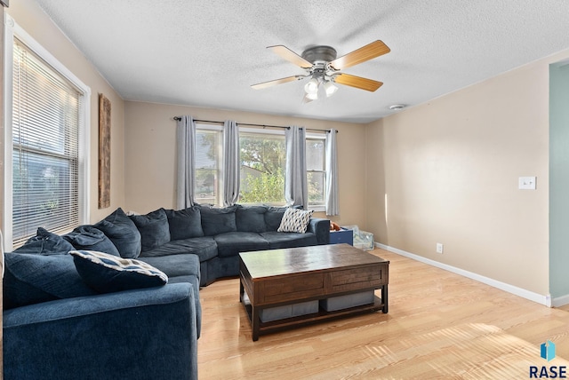 living room featuring a textured ceiling, light hardwood / wood-style flooring, and ceiling fan