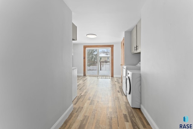 laundry room with cabinets, washer and dryer, and light hardwood / wood-style flooring