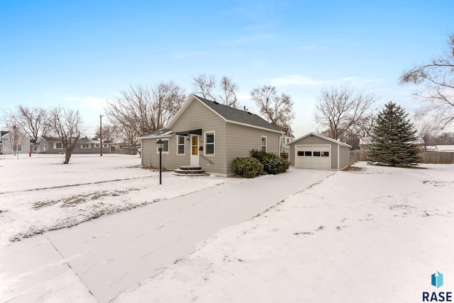 view of snowy exterior with a garage and an outdoor structure