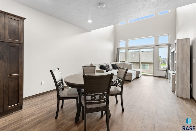 dining space featuring a high ceiling and light wood-type flooring