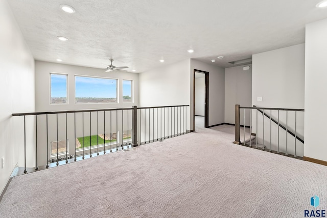 carpeted empty room with a textured ceiling