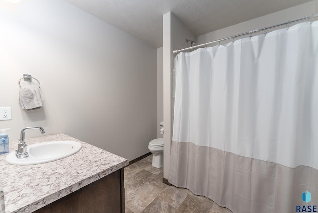 bathroom featuring vanity, toilet, and a textured ceiling