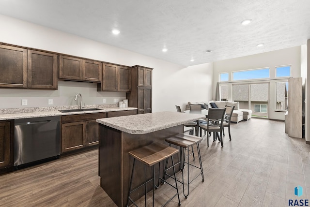 kitchen featuring sink, dark brown cabinets, dishwasher, and a kitchen island