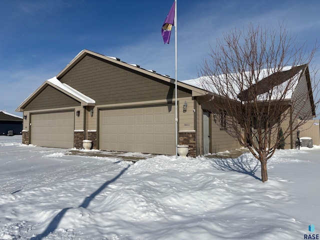 view of front of property featuring an attached garage and stone siding