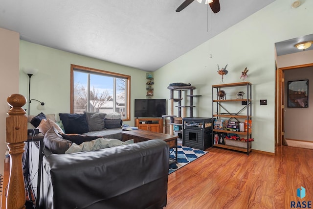 living room featuring hardwood / wood-style flooring, ceiling fan, and lofted ceiling