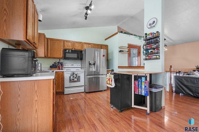 kitchen with lofted ceiling, white electric range, stainless steel fridge with ice dispenser, and light wood-type flooring