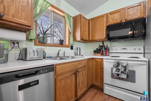 kitchen featuring white electric stove, lofted ceiling, sink, stainless steel dishwasher, and light hardwood / wood-style floors