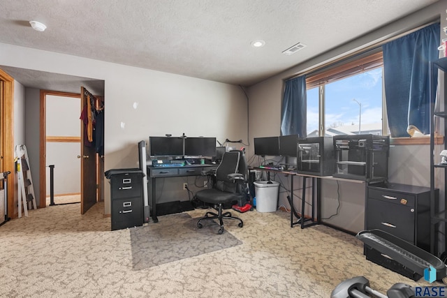 home office featuring carpet floors and a textured ceiling