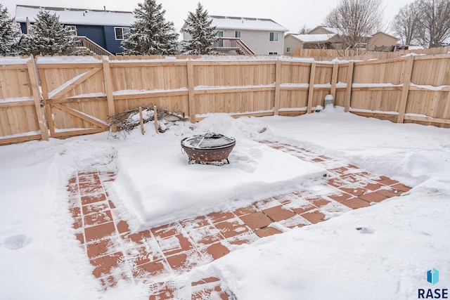 yard layered in snow featuring a fire pit