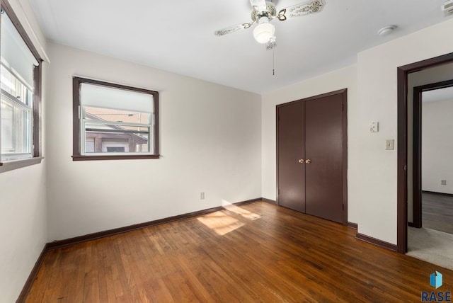 unfurnished bedroom with ceiling fan, dark hardwood / wood-style flooring, and a closet