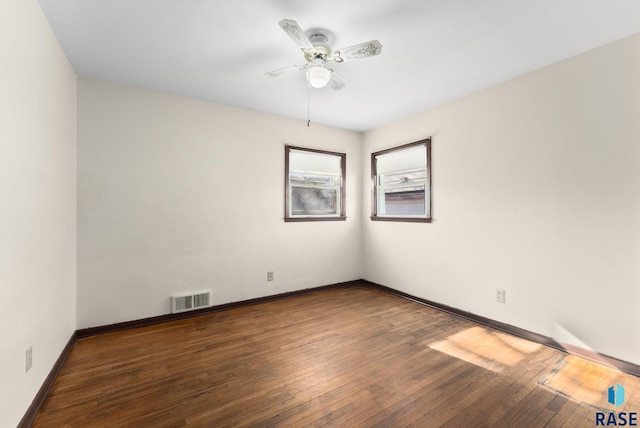 spare room with dark wood-type flooring and ceiling fan