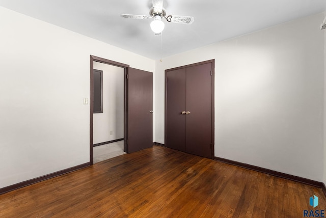 unfurnished bedroom with dark hardwood / wood-style floors, ceiling fan, and a closet