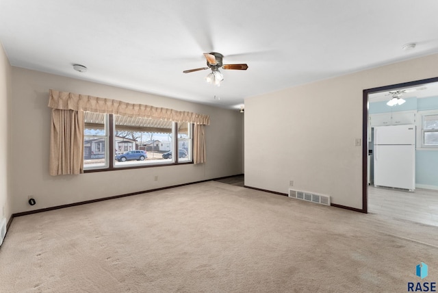 empty room featuring light colored carpet and ceiling fan