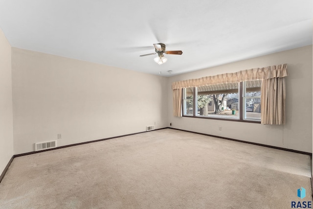 unfurnished room with ceiling fan and carpet