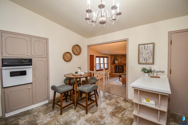 dining space with an inviting chandelier and a fireplace