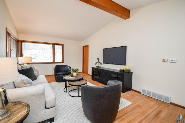 living room with vaulted ceiling with beams and light hardwood / wood-style floors