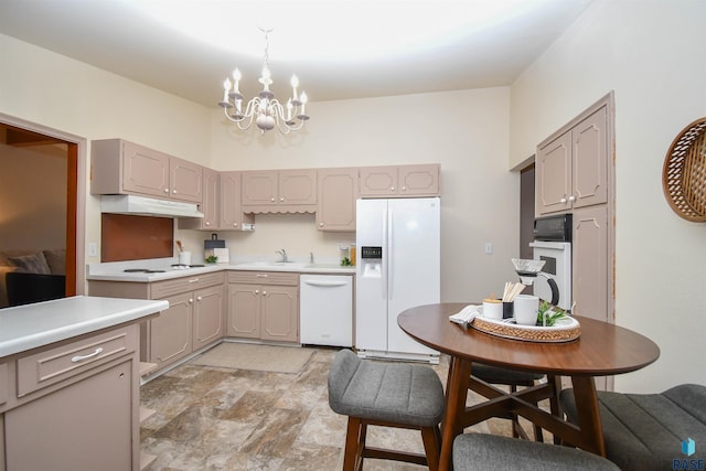 kitchen featuring an inviting chandelier, white appliances, decorative light fixtures, and sink