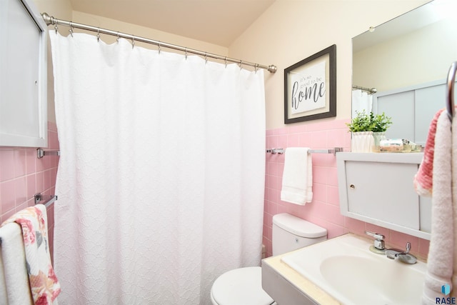 bathroom with vanity, tile walls, and toilet