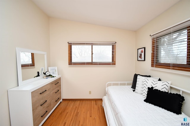 bedroom with lofted ceiling and light hardwood / wood-style floors