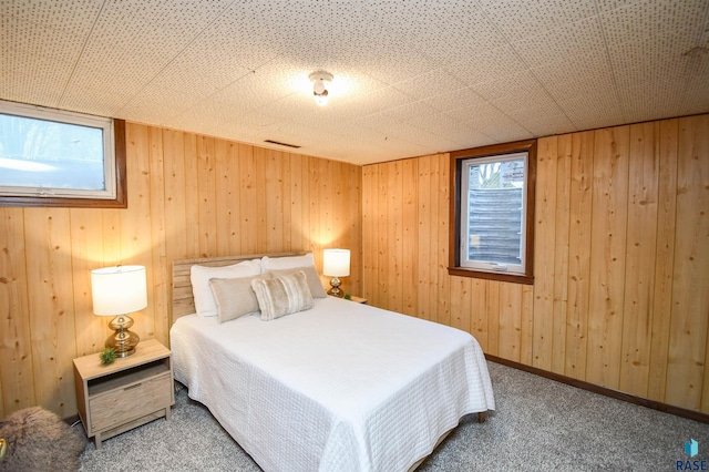 unfurnished bedroom with carpet floors and wood walls