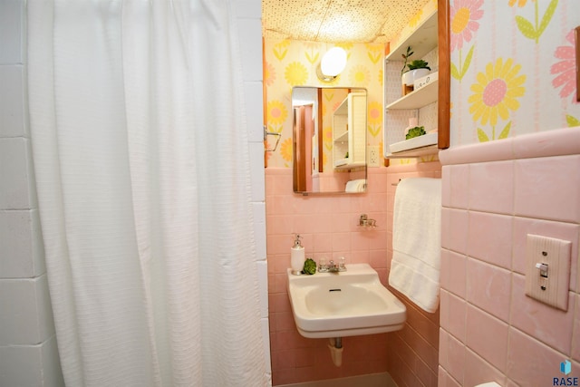 bathroom featuring tile walls and sink