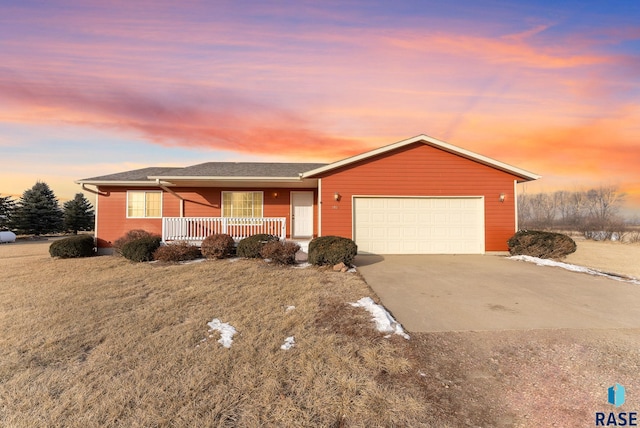 single story home featuring a garage, covered porch, and a lawn