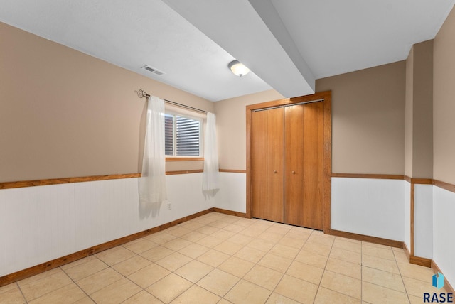 unfurnished bedroom featuring light tile patterned floors and a closet