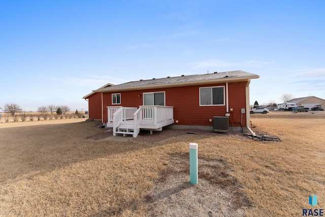 rear view of property featuring a yard, central AC unit, and a deck