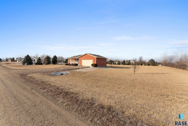 view of yard with a garage and a rural view