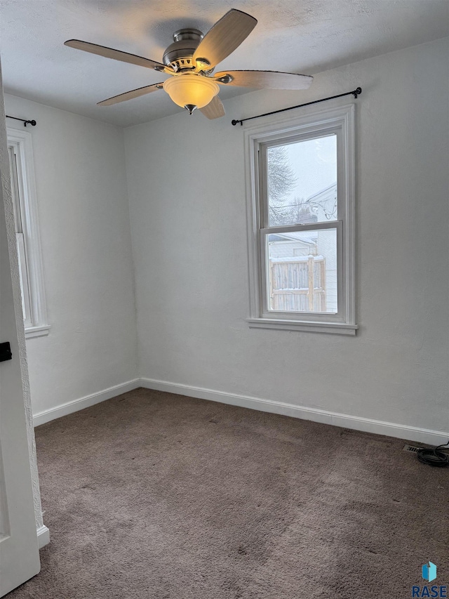 carpeted spare room featuring ceiling fan