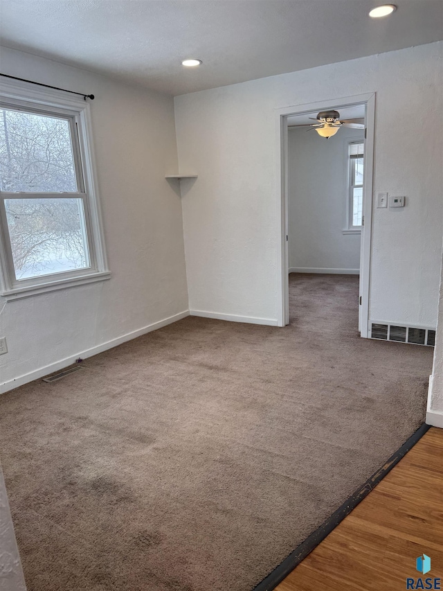 spare room with ceiling fan, a healthy amount of sunlight, and carpet flooring