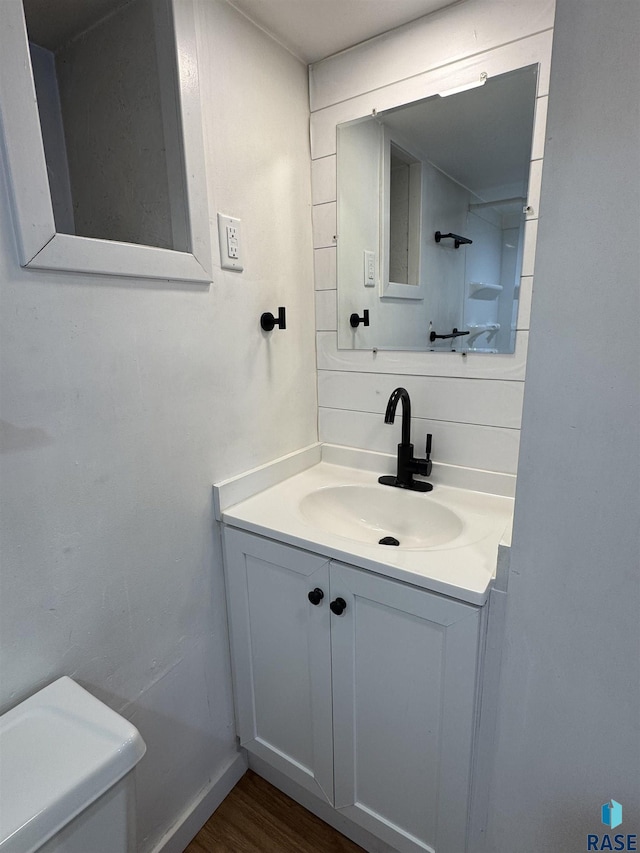 bathroom with vanity, wood-type flooring, and toilet