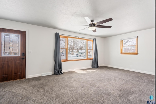 interior space with ceiling fan and a textured ceiling