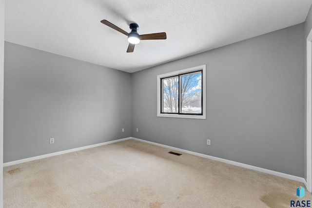 spare room featuring ceiling fan, carpet flooring, and a textured ceiling